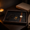 Lumidusk Rest valet tray on a dark nightstand by candlelight, holding glasses, brass keys, a leather watch and a gold ring